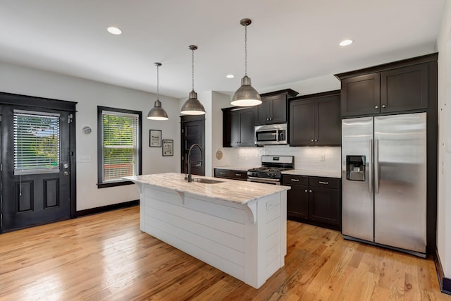 2136 Buena Vista Pike Unit B, Nashville, TN 37218 - kitchen with appliances with stainless steel finishes, light stone countertops, backsplash, a kitchen island with sink, and light wood finished floors