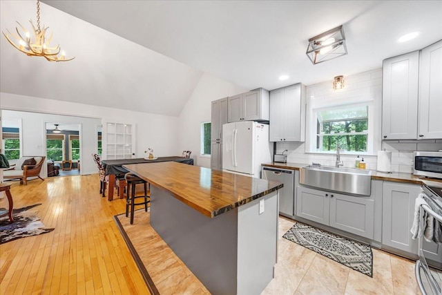 802 Evans Rd, Winchester, TN 37398 - kitchen with appliances with stainless steel finishes, gray cabinets, butcher block counters, vaulted ceiling, and a breakfast bar area