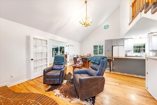 802 Evans Rd, Winchester, TN 37398 - living room featuring high vaulted ceiling, light wood-style flooring, a chandelier, french doors, and healthy amount of natural light