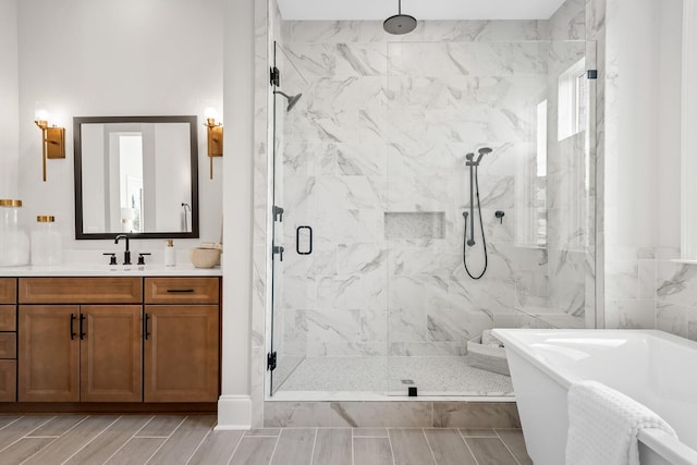 7262 Murrel Dr, Franklin, TN 37064 - bathroom featuring a marble finish shower, a freestanding tub, vanity, and wood tiled floors