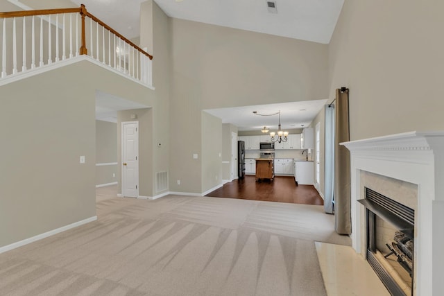 3133 Winberry Dr, Franklin, TN 37064 - unfurnished living room with a chandelier, a towering ceiling, carpet floors, and a high end fireplace