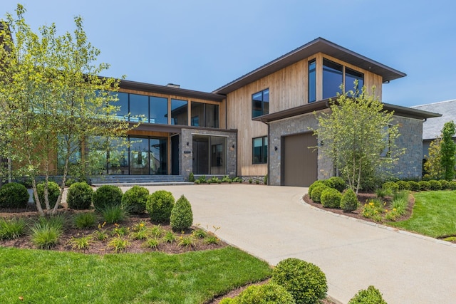 8005 Backwoods Dr, College Grove, TN 37046 - modern home featuring stone siding, concrete driveway, and a garage