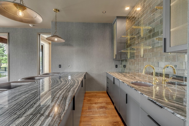 8005 Backwoods Dr, College Grove, TN 37046 - kitchen with wood finished floors, gray cabinets, light stone countertops, pendant lighting, and tasteful backsplash