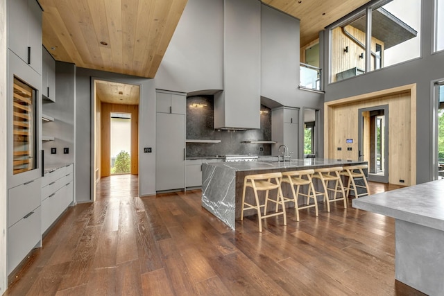 8005 Backwoods Dr, College Grove, TN 37046 - kitchen with modern cabinets, wood ceiling, dark wood-type flooring, plenty of natural light, and a breakfast bar area