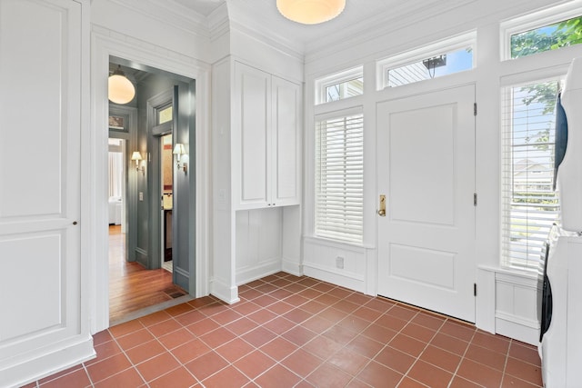 1504 Sweetbriar Ave, Nashville, TN 37212 - foyer entrance featuring stacked washer / dryer, a decorative wall, ornamental molding, and dark tile patterned flooring