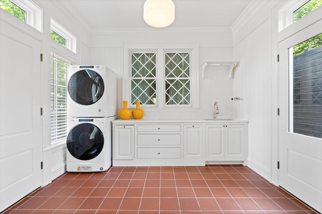 1504 Sweetbriar Ave, Nashville, TN 37212 - laundry area featuring stacked washer / dryer, cabinet space, dark tile patterned floors, and ornamental molding