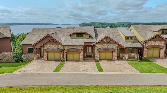 55B Oasis Ln, Savannah, TN 38372 - view of front of house with stone siding, driveway, a shingled roof, and a garage
