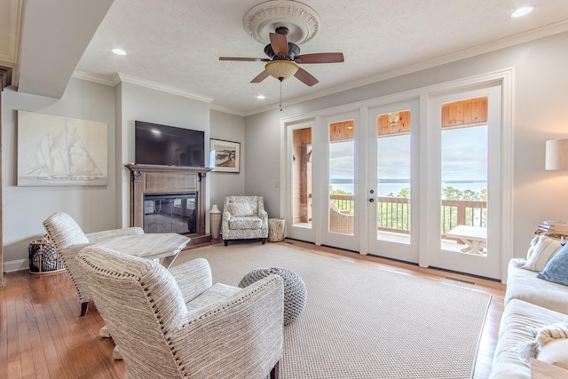 55B Oasis Ln, Savannah, TN 38372 - living area featuring light wood finished floors, recessed lighting, a glass covered fireplace, ceiling fan, and ornamental molding