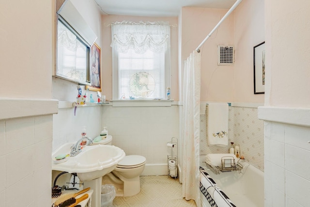 607 N 2nd St N, Clarksville, TN 37040 - full bath featuring a bathtub, tile walls, a shower with shower curtain, and wainscoting