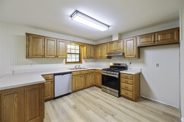 17930 Main St W, Huntingdon, TN 38344 - kitchen with stainless steel appliances, under cabinet range hood, brown cabinets, and light wood-style floors