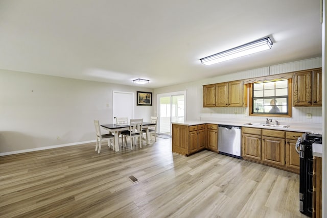 17930 Main St W, Huntingdon, TN 38344 - kitchen with stainless steel appliances, brown cabinetry, light wood finished floors, light countertops, and a peninsula