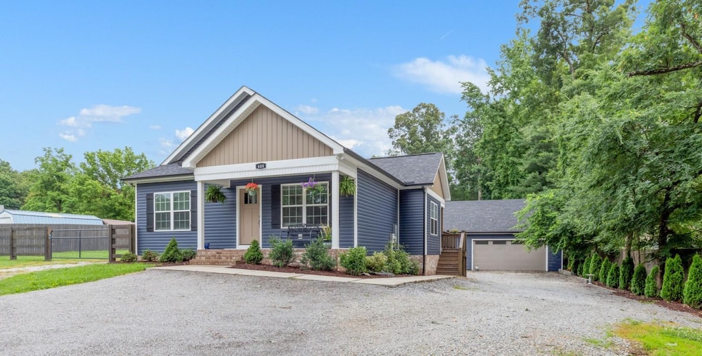 608 Luther Rd, Dickson, TN 37055 - view of front facade featuring gravel driveway, board and batten siding, roof with shingles, covered porch, and an outbuilding