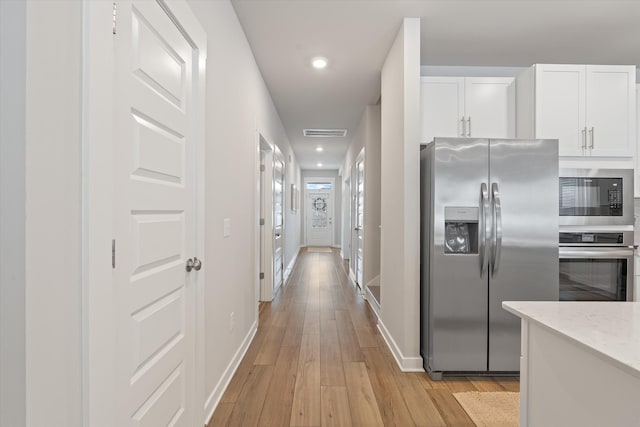 1081 Pebble Run Rd, Hendersonville, TN 37075 - kitchen featuring stainless steel appliances, white cabinets, light wood-style floors, light stone counters, and recessed lighting