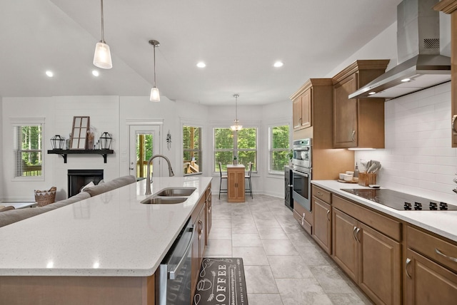 4049 Sadie Grace Way NW, Clarksville, TN 37042 - kitchen with wall chimney exhaust hood, black electric stovetop, stainless steel double oven, a large fireplace, and a kitchen island with sink