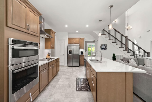 4049 Sadie Grace Way NW, Clarksville, TN 37042 - kitchen featuring stainless steel appliances, open floor plan, wall chimney exhaust hood, a center island with sink, and decorative light fixtures