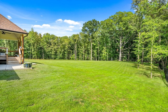 4049 Sadie Grace Way NW, Clarksville, TN 37042 - view of grassy yard featuring ceiling fan, a wooden deck, and a forest view