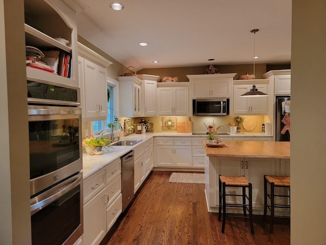 315 Gun Club Rd, Nashville, TN 37205 - kitchen with stainless steel appliances, light countertops, a breakfast bar area, white cabinetry, and recessed lighting