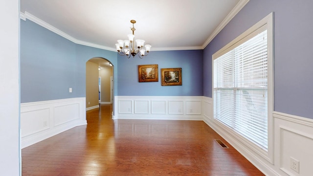 1007 Via Francesco Way, Spring Hill, TN 37174 - unfurnished room with arched walkways, wainscoting, crown molding, a chandelier, and dark wood finished floors