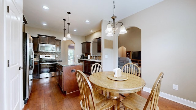 1007 Via Francesco Way, Spring Hill, TN 37174 - dining room featuring arched walkways, dark wood-style flooring, a chandelier, and recessed lighting
