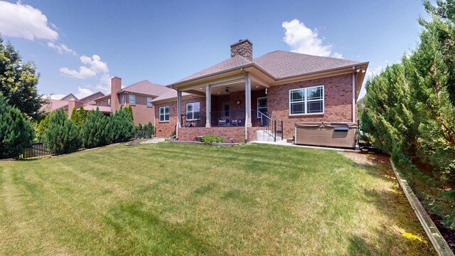 1007 Via Francesco Way, Spring Hill, TN 37174 - back of property with a hot tub, a ceiling fan, brick siding, and a chimney