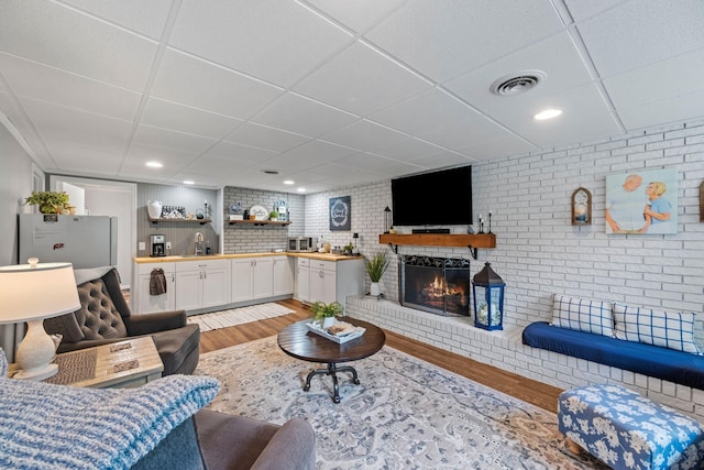 1400 Manor Rd, Columbia, TN 38401 - living room with light wood finished floors, a drop ceiling, a fireplace, and brick wall