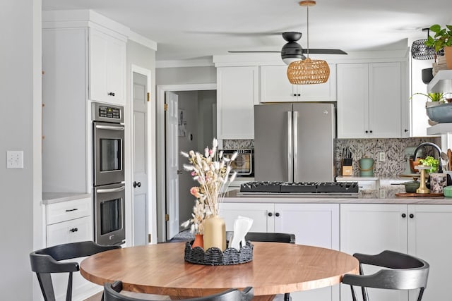 1400 Manor Rd, Columbia, TN 38401 - kitchen featuring stainless steel appliances, decorative backsplash, and white cabinetry