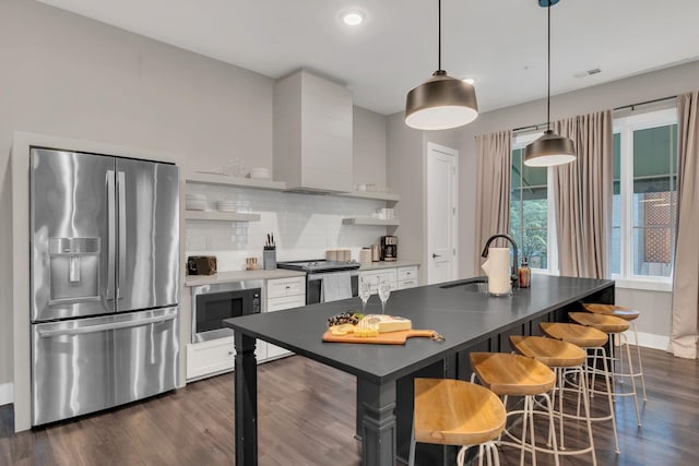 1320 5th Ave N Unit 4, Nashville, TN 37208 - kitchen featuring appliances with stainless steel finishes, tasteful backsplash, white cabinetry, dark wood-style floors, and pendant lighting