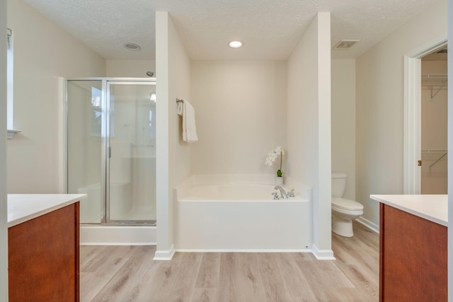 317 Sarava Ln, Smyrna, TN 37167 - bathroom with vanity, a shower stall, wood finished floors, a garden tub, and a textured ceiling