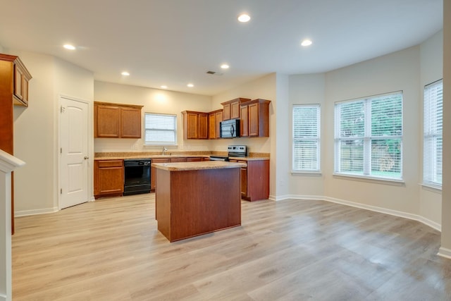 317 Sarava Ln, Smyrna, TN 37167 - kitchen featuring black appliances, light wood-style flooring, brown cabinets, a center island, and recessed lighting