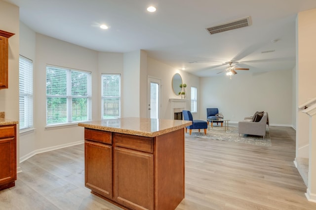 317 Sarava Ln, Smyrna, TN 37167 - kitchen with light wood-style floors, a fireplace, ceiling fan, a center island, and recessed lighting