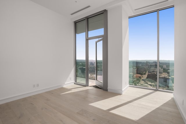 1616 W End Ave Unit 3304, Nashville, TN 37203 - unfurnished room featuring floor to ceiling windows, wood finished floors, and a city view