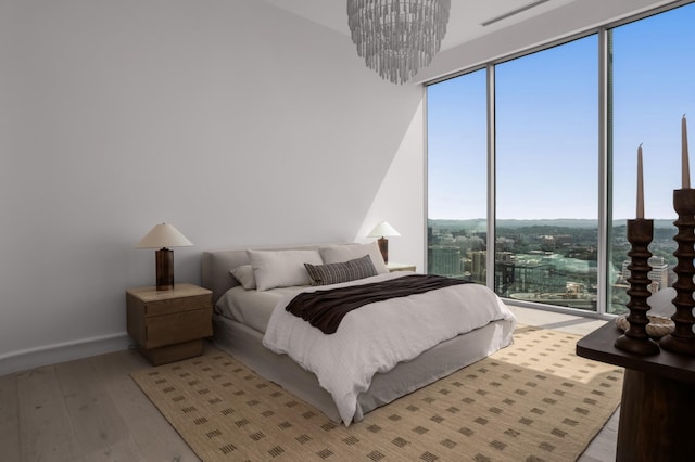 1616 W End Ave Unit 3304, Nashville, TN 37203 - bedroom featuring light wood-style flooring, multiple windows, and a chandelier