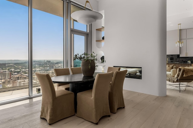 1616 W End Ave Unit 3304, Nashville, TN 37203 - dining area with light wood finished floors, expansive windows, a towering ceiling, and a city view