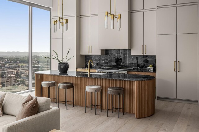 1616 W End Ave Unit 3304, Nashville, TN 37203 - kitchen featuring decorative backsplash, a kitchen bar, light wood-style flooring, and healthy amount of natural light