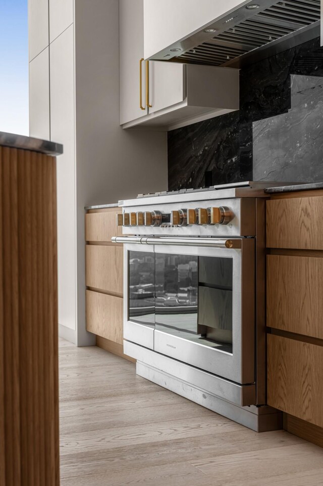 1616 W End Ave Unit 3304, Nashville, TN 37203 - kitchen featuring exhaust hood, light wood-style floors, and oven