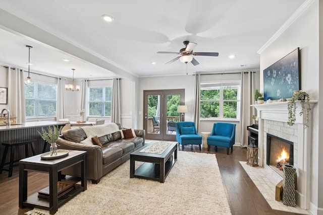 2717 Cloister Ln, Thompsons Station, TN 37179 - living room with ornamental molding, a brick fireplace, wood finished floors, a ceiling fan, and a chandelier