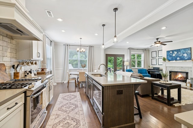 2717 Cloister Ln, Thompsons Station, TN 37179 - kitchen featuring appliances with stainless steel finishes, a brick fireplace, a breakfast bar, crown molding, and custom exhaust hood