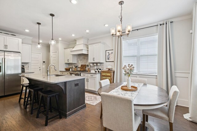 2717 Cloister Ln, Thompsons Station, TN 37179 - kitchen featuring stainless steel fridge with ice dispenser, premium range hood, tasteful backsplash, a kitchen breakfast bar, and ornamental molding