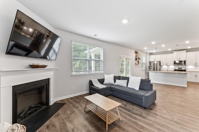 1045 Alta Vista Ln, Smyrna, TN 37167 - living area with light wood-style flooring, recessed lighting, and a glass covered fireplace