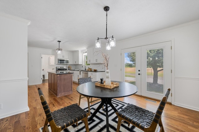 2746 Kinneys Rd, Cedar Hill, TN 37032 - dining space featuring light wood-style flooring, crown molding, and french doors