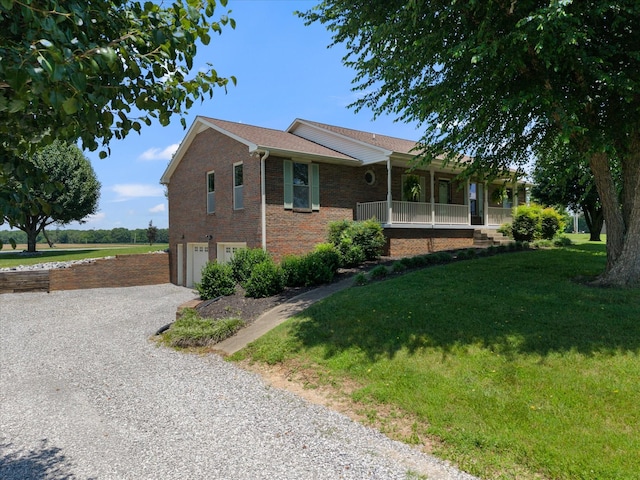 2746 Kinneys Rd, Cedar Hill, TN 37032 - ranch-style house featuring a garage, gravel driveway, a front lawn, brick siding, and covered porch