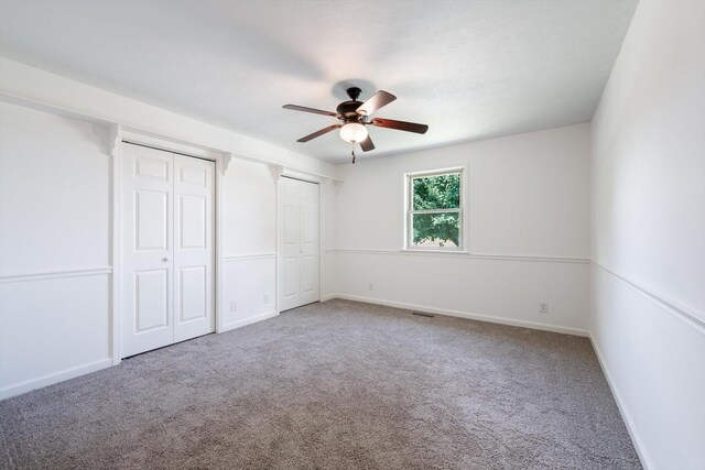 2746 Kinneys Rd, Cedar Hill, TN 37032 - unfurnished bedroom featuring two closets, carpet floors, and a ceiling fan