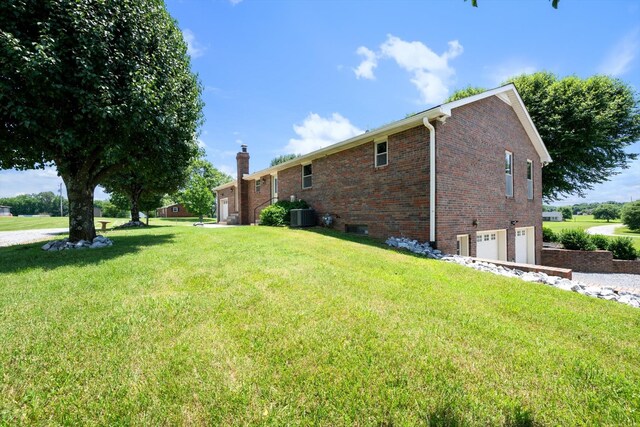 2746 Kinneys Rd, Cedar Hill, TN 37032 - view of property exterior featuring an attached garage, brick siding, a chimney, and a yard