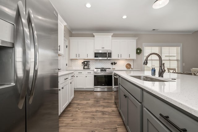 319 Edna May Dr, Murfreesboro, TN 37128 - kitchen with appliances with stainless steel finishes, gray cabinets, crown molding, backsplash, and dark wood finished floors