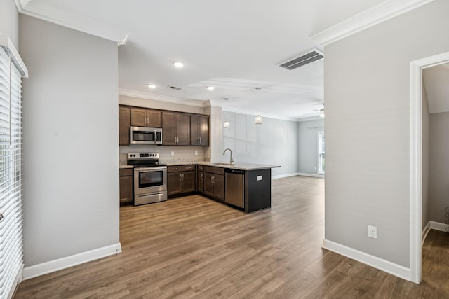 2557 Napa Valley Way, Columbia, TN 38401 - kitchen featuring stainless steel appliances, ornamental molding, a peninsula, a ceiling fan, and dark brown cabinets