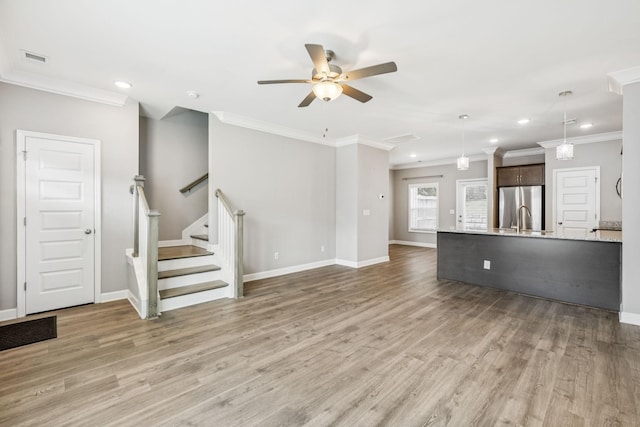 2557 Napa Valley Way, Columbia, TN 38401 - unfurnished living room featuring a ceiling fan, recessed lighting, light wood-type flooring, ornamental molding, and stairs