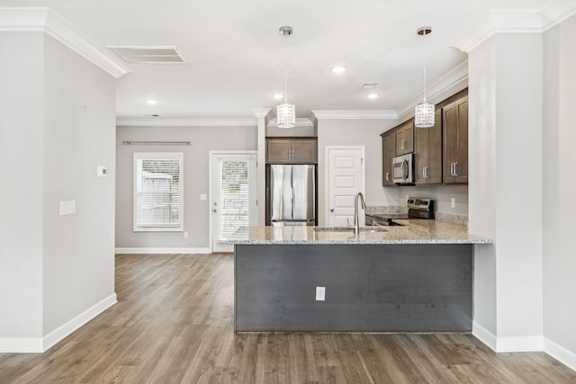 2557 Napa Valley Way, Columbia, TN 38401 - kitchen with stainless steel appliances, dark brown cabinets, ornamental molding, light stone countertops, and light wood-style flooring