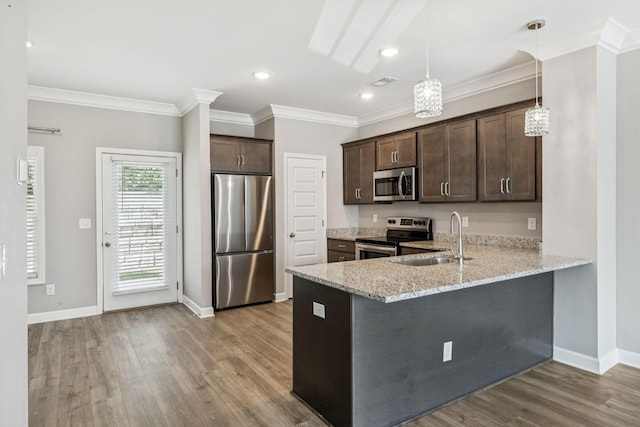 2557 Napa Valley Way, Columbia, TN 38401 - kitchen with stainless steel appliances, dark brown cabinetry, a peninsula, light stone countertops, and wood finished floors