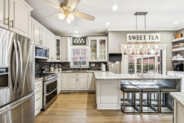 314 W 6th St, Columbia, TN 38401 - kitchen featuring stainless steel appliances, a kitchen breakfast bar, decorative backsplash, glass insert cabinets, and ornamental molding