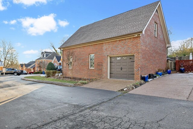 314 W 6th St, Columbia, TN 38401 - view of side of home featuring brick siding, a shingled roof, and an attached garage